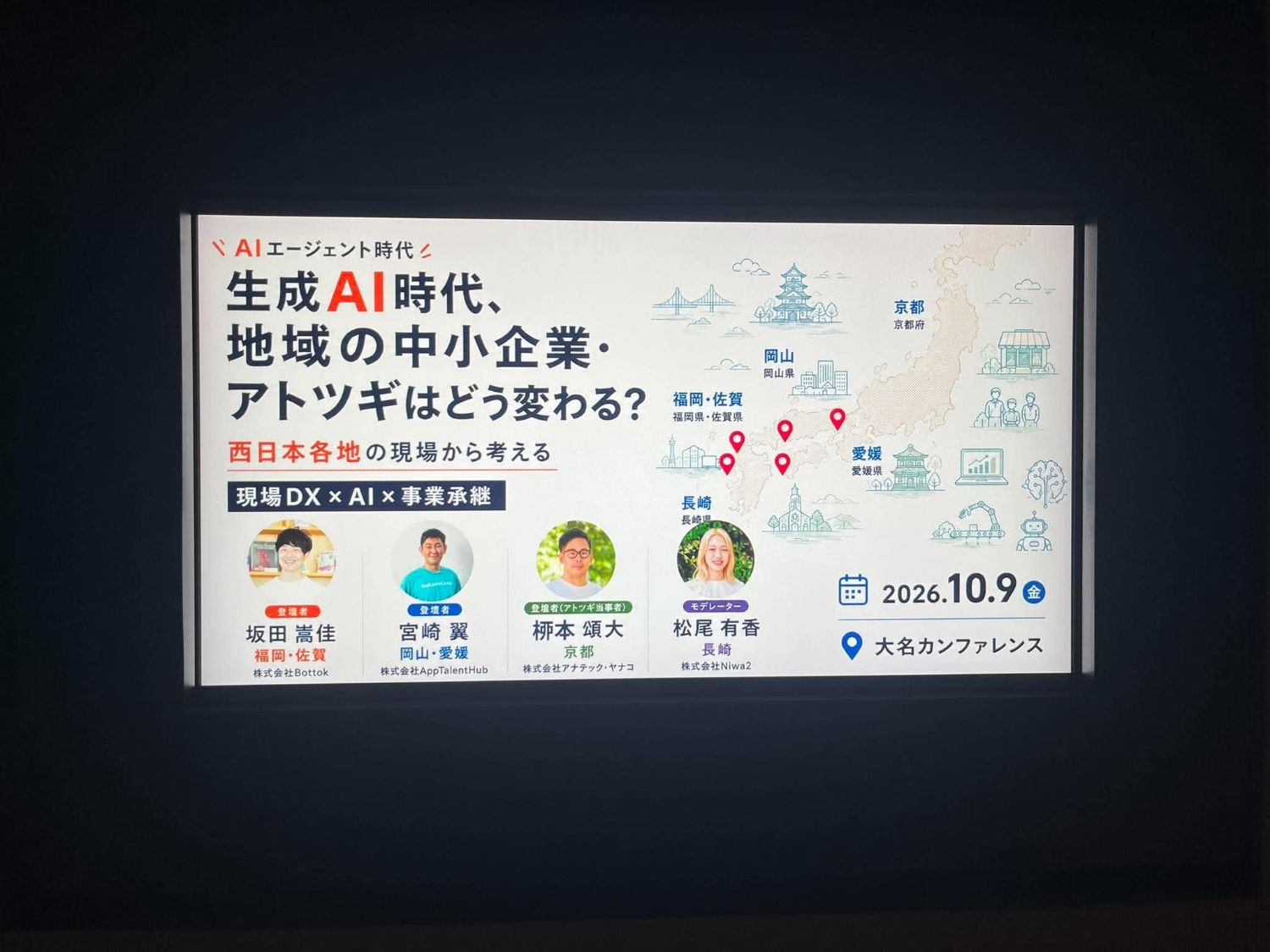 会場のスクリーンに映ったRAMEN TECH 2026「生成AI時代、地域の中小企業・アトツギはどう変わる？」の告知バナー